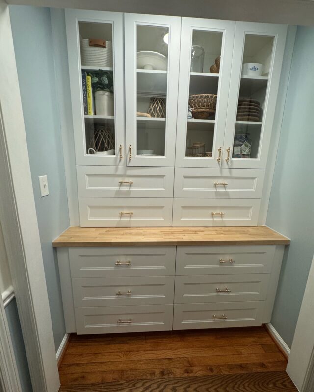 After: white built-in pantry with glass-front upper cabinets, drawers, and a butcher block counter