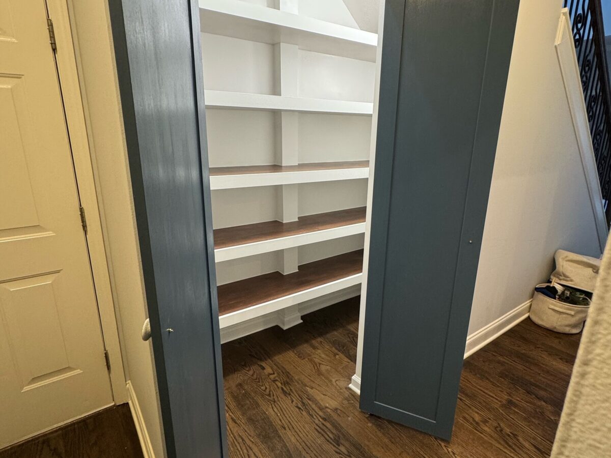 Custom walk-in pantry with white shelving and stained wood shelf tops