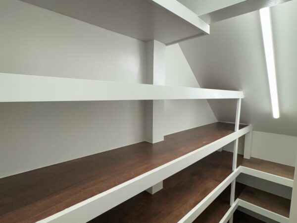 Wraparound pantry shelves with dark stained wood tops