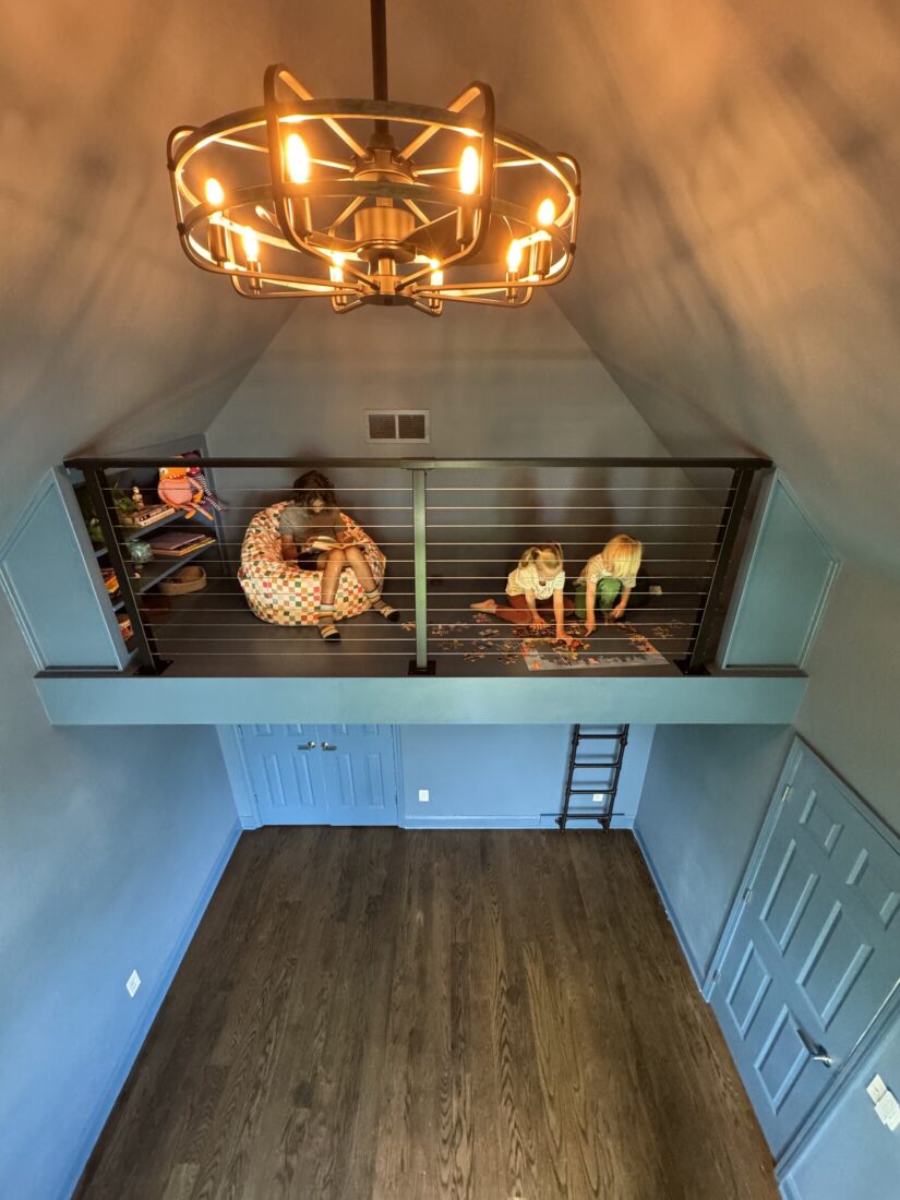 Play loft with cable railing and ladder built into vaulted space above a closet