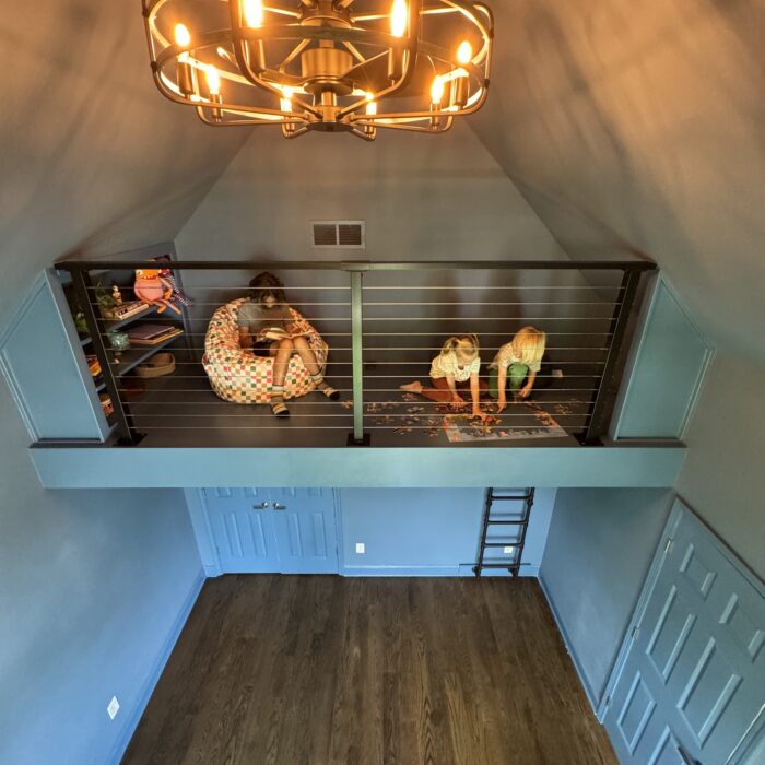 Play loft with cable railing and ladder built into vaulted space above a closet